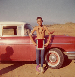 Loinclothed hobby; Obr�zek dne - the picture od the day - �awa rel -  Skinny boy in indian dance costume on red car in desert - 1950