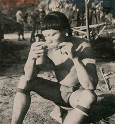 Loinclothed hobby; Obr�zek dne - the picture od the day - �awa rel - Black and white photograph of a Wai Wai man sitting and painting his face.